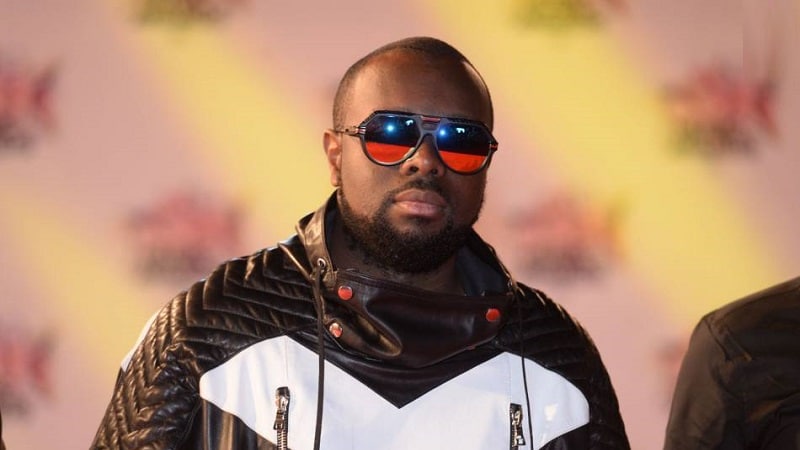 Maître Gims pose sans ses légendaires lunettes noires et avec son bébé